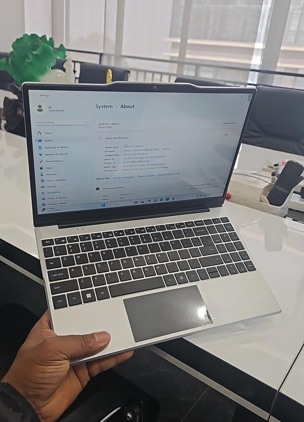 A Kotlead Laptop held open, showing its Windows 11 system information.